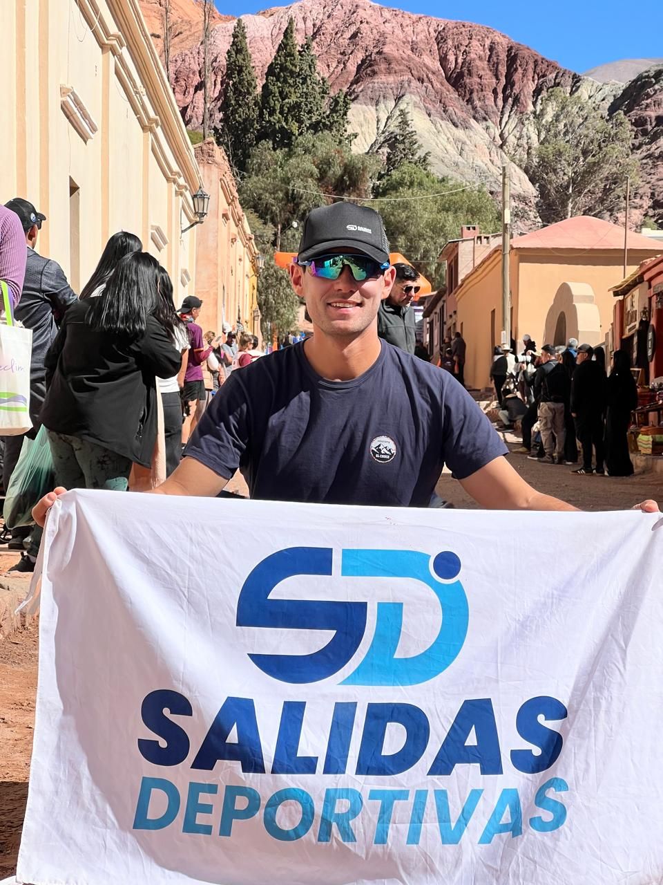 Corredor con la bandera de Salidas Deportivas en Purmamarca